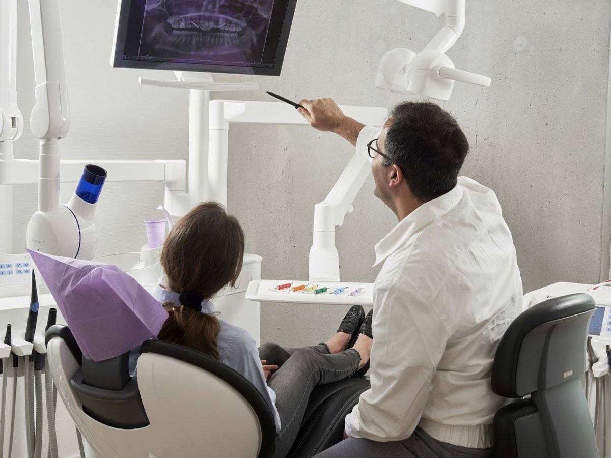 A dentist explaining a dental X-ray to a patient
